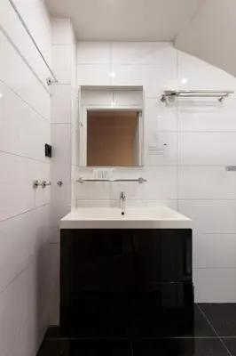 a white bathroom with a sink and a mirror at Midtown Hotel triple in Amsterdam