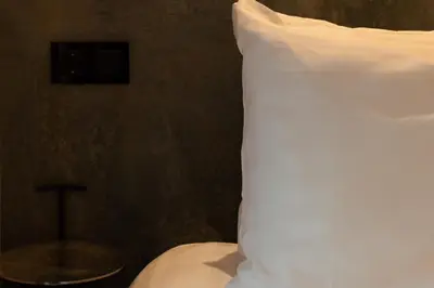 a white pillow sitting on top of a bed at Midtown Hotel triple in Amsterdam