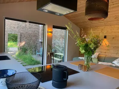 a kitchen with a table with a vase of flowers at Behouden Huis in Ons Belang