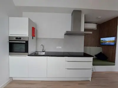 a kitchen with white cabinets and a sink at Comfort Apartment Hoofddorp near Amsterdam Schiphol in Hoofddorp