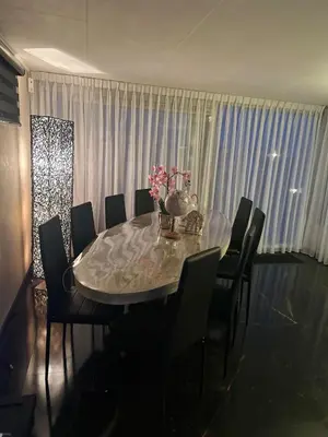 a dining room with a glass table and chairs at woonboot de dobber loosdrechtse plassen 4-8 personen in Loosdrecht