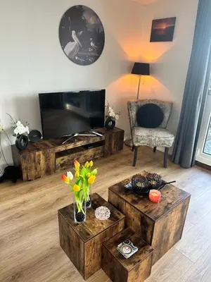 a living room with a flat screen tv and a chair at Woonboot De Witte loosdrechtse plassen in Loosdrecht