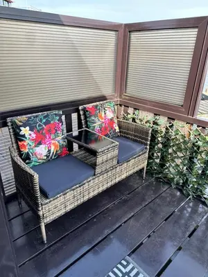 two wicker chairs and a table on a porch at Woonboot De Witte loosdrechtse plassen in Loosdrecht