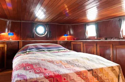 a bedroom in a boat with a bed in it at art deco houseboat on super location in Amsterdam