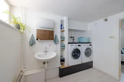 a bathroom with a sink and a washing machine at Family home in Haarlem with garden, near beach & Amsterdam in Haarlem