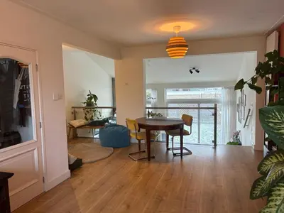 a dining room and living room with a table and chairs at Family home in Haarlem with garden, near beach & Amsterdam in Haarlem