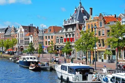 a city with boats docked in a river with buildings at Family home in Haarlem with garden, near beach & Amsterdam in Haarlem