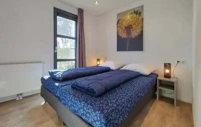 a bedroom with a large bed with blue pillows on it at Gorgeous Home In Nijkerk With Wifi in Nijkerk