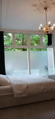a bedroom with a bed in front of a window at Gouda city center apartment with private garden and 2 bicycles in Gouda