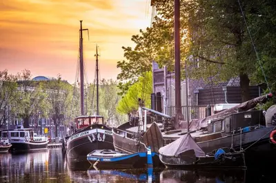 a group of boats docked in a canal at Gouda city center apartment with private garden and 2 bicycles in Gouda
