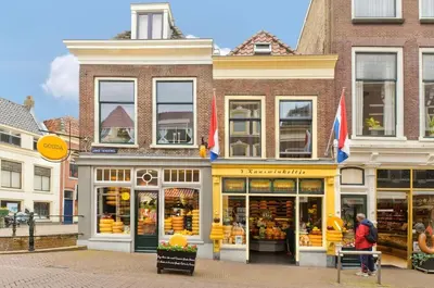 a store front of a building on a city street at Gouda city center apartment with private garden and 2 bicycles in Gouda