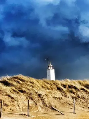 a white lighthouse sitting on top of a hill at Studio 21 stylish and luxurious apartment in Noordwijk