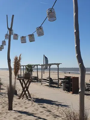 a picnic table on the beach next to the ocean at Studio 21 stylish and luxurious apartment in Noordwijk