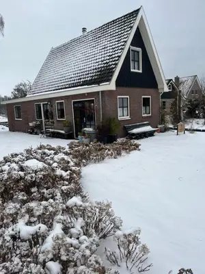 a house with a snow covered yard in front of it at Bij De Neckermolen- Bed and Stay Beemster in Zuidoostbeemster