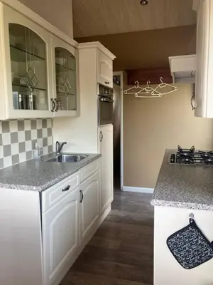 a kitchen with white cabinets and a sink at Rekerlanden 218 by ZILT in Warmenhuizen