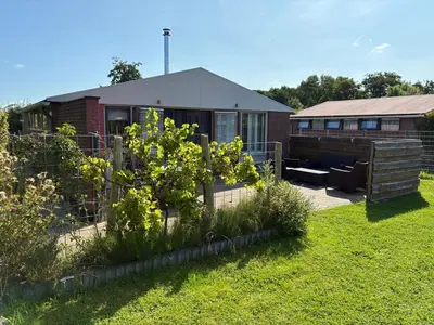 a backyard of a house with a fence and a garden at Rekerlanden 218 by ZILT in Warmenhuizen
