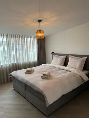 a bedroom with a large bed with towels on it at Blvd 79 in Katwijk aan Zee