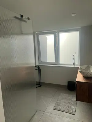 a bathroom with a shower and a sink and a window at Blvd 79 in Katwijk aan Zee