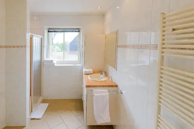 a white bathroom with a sink and a mirror at Buitenplaats Langewijk in Zuidoostbeemster