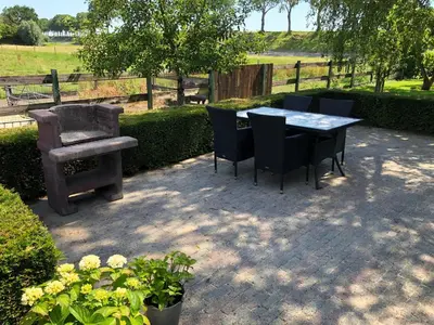 a table and chairs and a chair and a bench at Buitenplaats Langewijk in Zuidoostbeemster