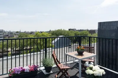 a table and chairs on a balcony with flowers at Central HotSpot Apartment in Amsterdam