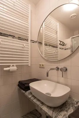 a white bathroom with a sink and a mirror at Central HotSpot Apartment in Amsterdam