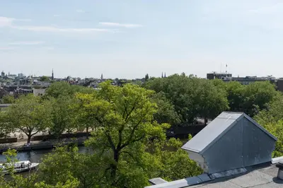 a building sitting on top of a roof next to trees at Central HotSpot Apartment in Amsterdam