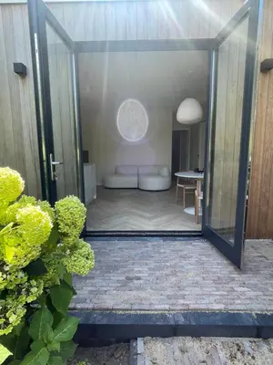 a glass door leading into a room with a couch at Haarlems Huisje in Haarlem