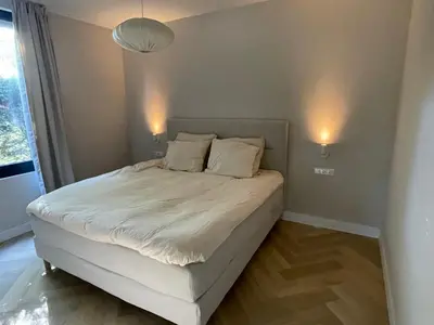a bed in a bedroom with two lights on the wall at Haarlems Huisje in Haarlem