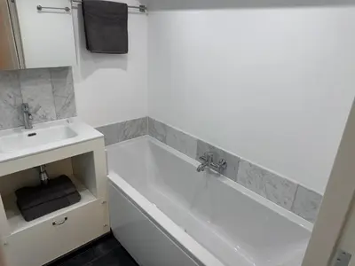 a bathroom with a white tub and a sink at Herengracht 204 Souterrain Studio Apt without kitchen in Amsterdam