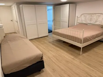 a bedroom with two beds and white cabinets at Herengracht 204 Souterrain Studio Apt without kitchen in Amsterdam