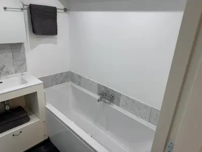 a white bathroom with a tub and a sink at Herengracht 204 Souterrain Studio Apt without kitchen in Amsterdam