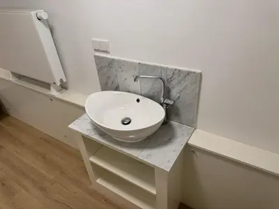 a bathroom with a white sink on a counter at Herengracht 204 Souterrain Studio Apt without kitchen in Amsterdam