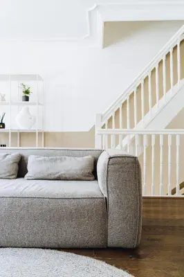 a couch in a living room with a staircase at Staal House in Amsterdam