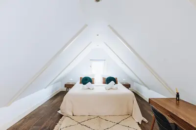a bedroom with a white bed with two pillows at Staal House in Amsterdam