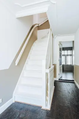 a staircase in a house with white walls and wood floors at Staal House in Amsterdam