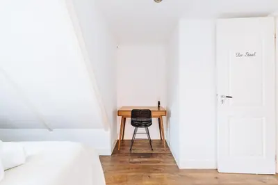 a bedroom with a table and a chair next to a door at Staal House in Amsterdam