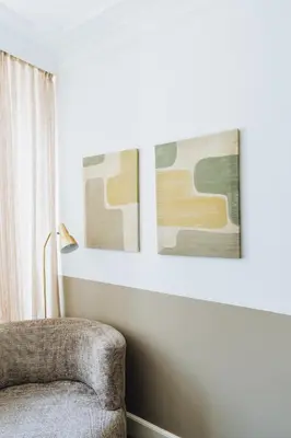 a living room with a chair and two framed pictures at Staal House in Amsterdam