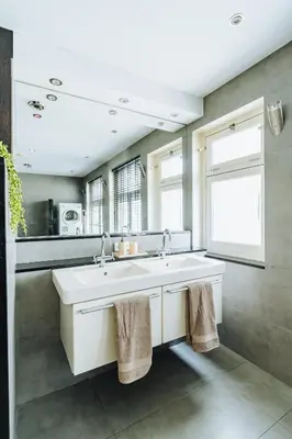 a white bathroom with a sink and a window at Staal House in Amsterdam