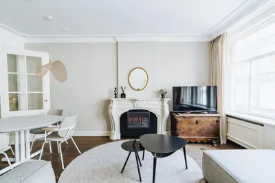 a living room with a fireplace and a table and chairs at Staal House in Amsterdam