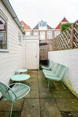 a group of chairs and a table on a patio at The Alkmaar Family House in Alkmaar