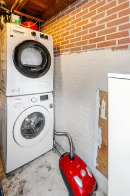 a washing machine sitting next to a brick wall at The Alkmaar Family House in Alkmaar