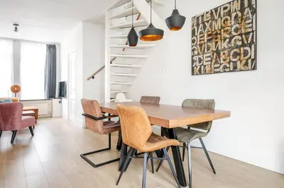 a dining room with a wooden table and chairs at The Alkmaar Family House in Alkmaar