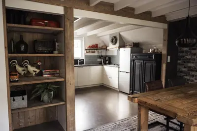 a kitchen with white appliances and a wooden table at Another day in paradise in Tuitjenhorn