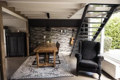 a dining room with a table and chairs and a brick wall at Another day in paradise in Tuitjenhorn