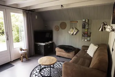 a living room with a couch and a television at Another day in paradise in Tuitjenhorn