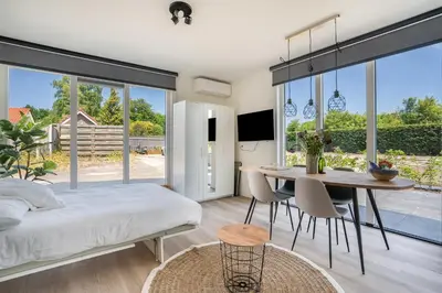 a bedroom with a bed and a table and chairs at Mereveld Studios in Utrecht