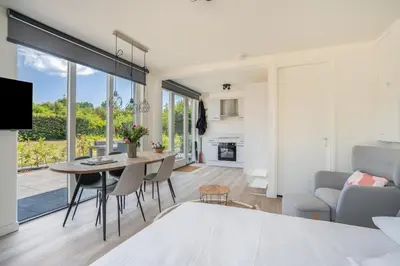 a dining room and living room with a table and chairs at Mereveld Studios in Utrecht
