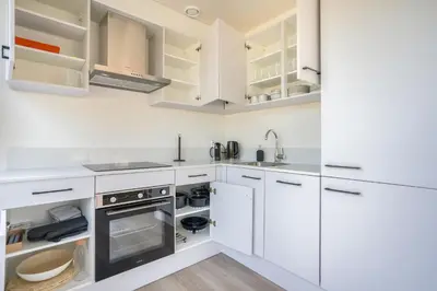 a white kitchen with white cabinets and appliances at Mereveld Studios in Utrecht