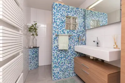 a bathroom with a white sink and blue tiles at Zaan City Deck in Zaandam